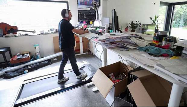 Belgian Yves Hanoulle, IT professional, walks on a treadmill installed under his desk, with the average of 20km daily, as he works in his home in Ghent, Belgium, in this June 11, photograph.