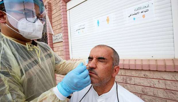 A Kuwait health ministry worker conducts a random test for the novel coronavirus (Covid-19) in Kuwait City, yesterday.