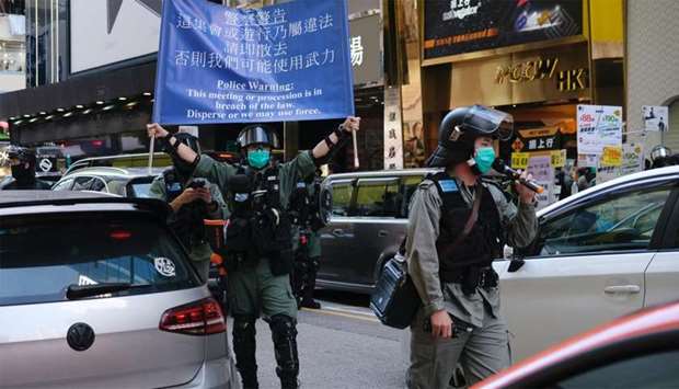 Riot police ask people to leave to avoid mass gathering during a silent protest against the looming national security legislation in Hong Kong