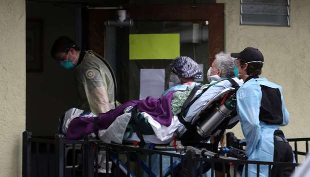 MEDICAL EMERGENCY: Emergency medical technicians move a patient on a gurney from an ambulance into the Gateway Care and Rehabilitation Center in Hayward, California, on April 16, 2020.
