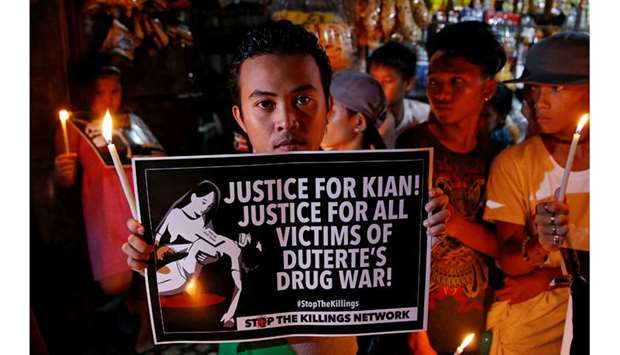 File photo shows protesters and residents hold lighted candles and placards at the wake of Kian delos Santos, a 17-year-old high school student, who was among the people shot dead in an escalation of President Rodrigo Duterteu2019s war on drugs in Caloocan city, Metro Manila on August 25, 2017.