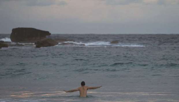 A swimmer wades to deeper water at Bondi Beach amidst the easing of the restrictions implemented to curb the spread of the coronavirus disease in Sydney, Australia.