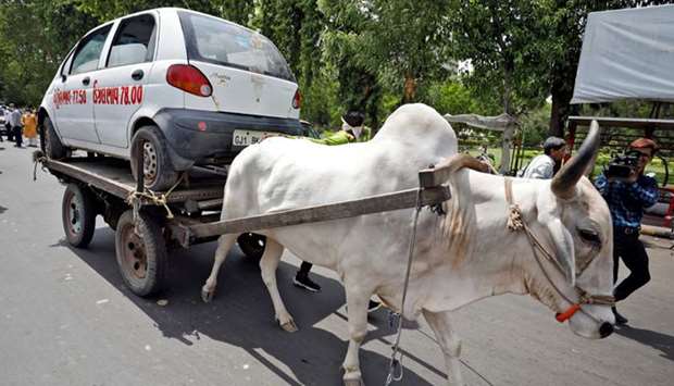 A car is carried on a bullock cart as part of a protest organised by the Congress party against the hike in fuel prices, in Ahmedabad, yesterday.
