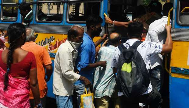 Commuters board a public bus after authorities eased restrictions in Kolkata yesterday.