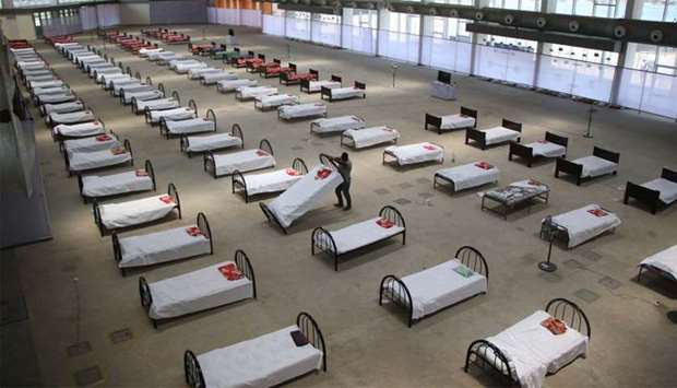 A worker arranges beds at quarantine centre set up in the Hapania International Fair Complex during a nationwide lockdown imposed as a preventive measure against the COVID-19 coronavirus, on the outskirts of Agartala