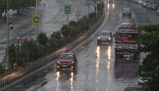 Commuters drive along Marine Drive as rain falls in Mumbai yesterday.
