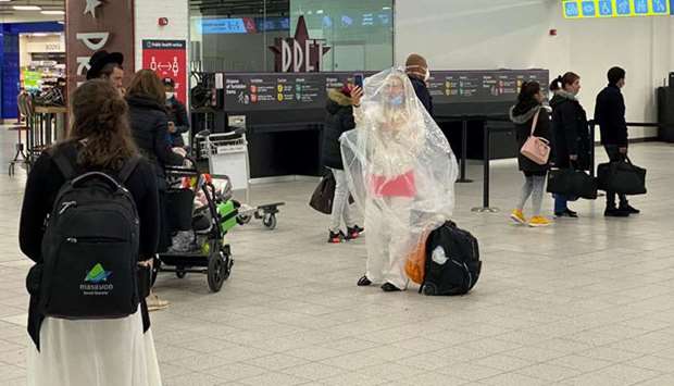 A passenger covered with a plastic bag is seen at Luton Airport, Luton, yesterday.