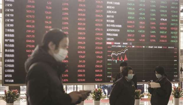 Employees and visitors wearing protective masks walk past an electronic stock board at the Shanghai Stock Exchange. Chinau2019s success in luring foreigners into its domestic debt market, the worldu2019s second largest, faces a new test in coming months as officials try to drum up interest in a record wave of bonds from local authorities.
