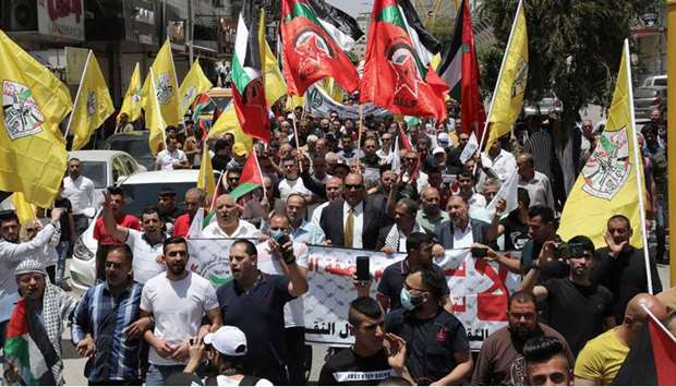 Palestinian supporters of the Fatah movement wave flags as they demonstrate in the West Bank city of Hebron, to mark 53 years of occupation and protest against Israelu2019s plan to annex parts of the occupied territory, yesterday.