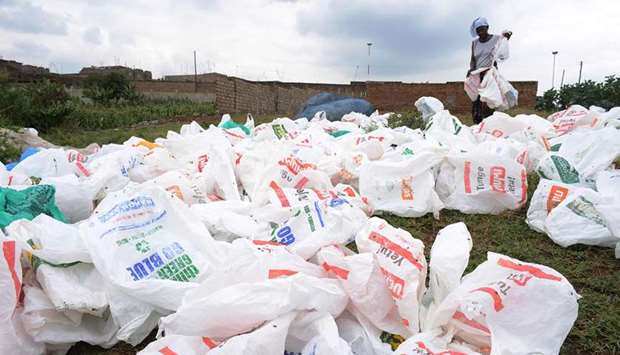 File photo shows a woman sorting out plastic bags after washing them for reuse at the shores of a river in Nairobi.