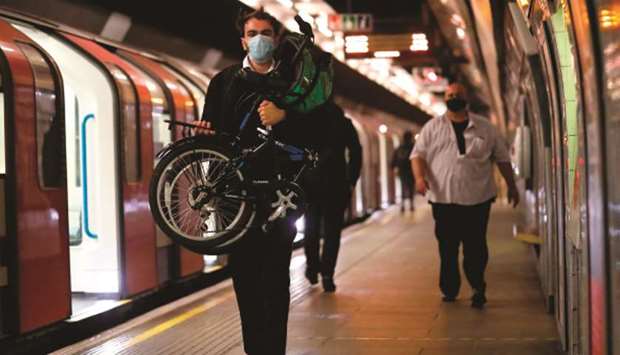 A commuter wears a face mask as he walks on the platform of a tube station in London yesterday as lockdown measures are eased during the novel coronavirus pandemic. Face coverings will soon be compulsory for people wanting to travel on public transport in England to limit the spread of coronavirus.