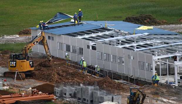 Workers construct a new quick-build dormitory for foreign workers in Singapore yesterday as the nation eases its partial lockdown restrictions aimed at curbing the spread of the Covid-19 novel coronavirus. The tiny city-state has  one of the highest Covid-19 caseloads in Asia.