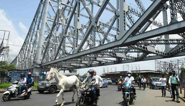 A horse rides through traffic along the Howrah Bridge after the government eased a nationwide lockdown imposed as a preventive measure against Covid-19, in Kolkata yesterday.