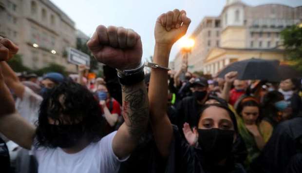 Protesters handcuff their wrists as they march the streets, as protests against the death in Minneapolis police custody of George Floyd continue, in Washington, US