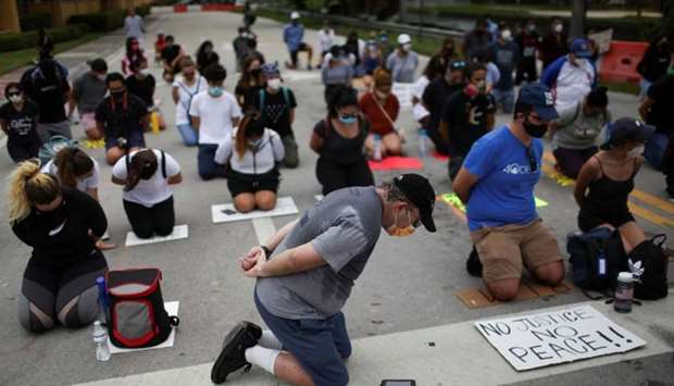 Demonstrators kneel as they take part in a protest against racial inequality in the aftermath of the death in Minneapolis police custody of George Floyd, outside Trump National Doral golf resort in Doral, Florida