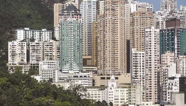 High rise buildings stand illuminated by sunlight in Hong Kong. Even as home prices and sales have dropped in many global markets such as London and Singapore, Hong Kong recorded 6,885 property deals in May, a 12-month high as the city eases pandemic measures.