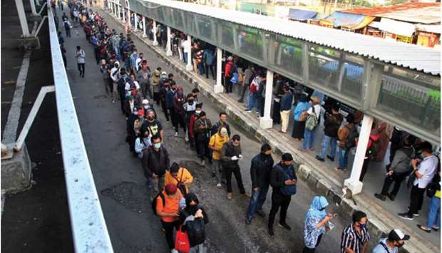 Commuter train passengers stand in lines as the government eases restrictions amid the coronavirus disease (Covid-19) outbreak in Bogor, near Jakarta, yesterday.