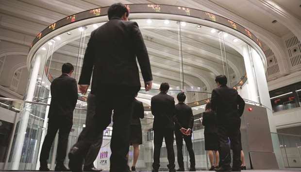 Visitors watch share prices at the Tokyo Stock Exchange. The Nikkei 225 closed up 1.4% to 23,178.10 points yesterday.