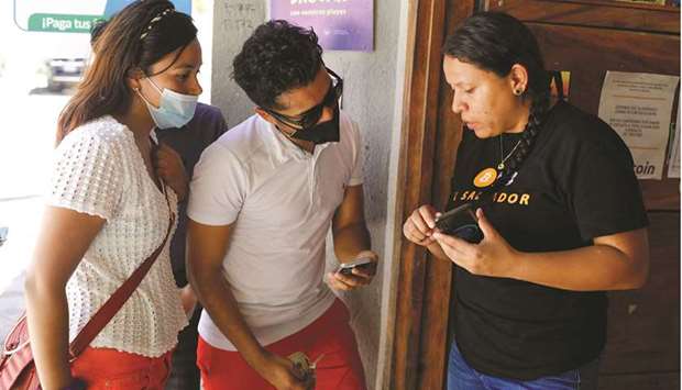 A couple make a bitcoin transaction at a bitcoin support office at El Zonte Beach in Chiltiupan, El Salvador. (Reuters)