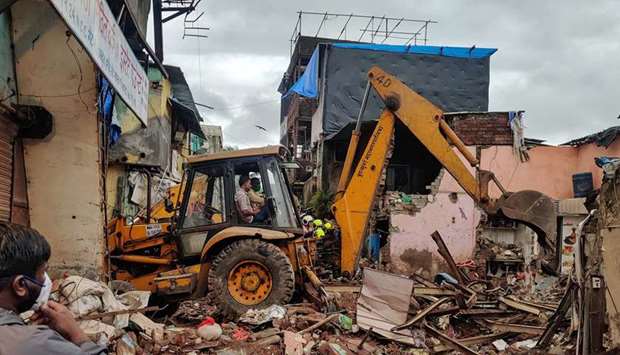 Rescue workers search for survivors in the debris after a residential building collapsed in Mumbai, India