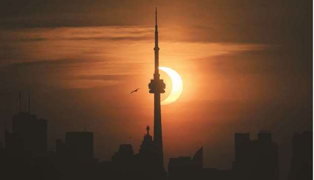 The sun rises behind the skyline during an annular eclipse yesterday in Toronto, Canada.