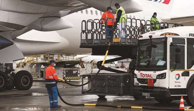 Workers connect a tanker truck to an Airbus A350 passenger plane, operated by Air France-KLM, during fueling with sustainable aviation fuel (SAF) ahead of a long-haul flight to Montreal, Canada, at Charles de Gaulle airport in Roissy, France, on May 18. Airbus says it plans to develop the worldu2019s first zero-emission commercial aircraft by 2035.