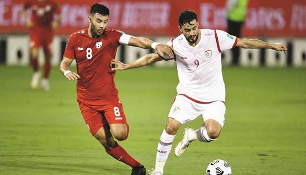 Afghanistanu2019s Farshad Noor (left) and Omanu2019s Abdulaziz al-Muqbali vie for the ball during the Asian qualifying match for the FIFA World Cup Qatar 2022 in Doha on Friday. PICTURE: Jayan Orma