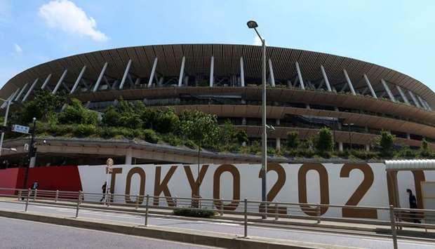People walk outside the Olympic Stadium (National Stadium) built for Tokyo Olympic Games