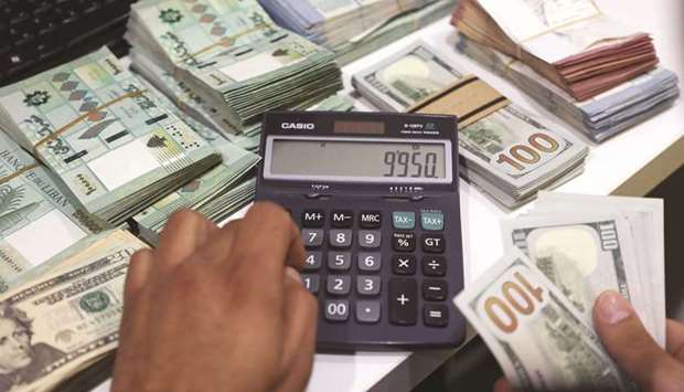 A man counts US dollar banknotes at a currency exchange shop in Beirut (file). Lebanonu2019s talks with the IMF over a $10bn bailout fell through after the central bank and lenders disputed u201cembedded lossesu201d in the financial sector.
