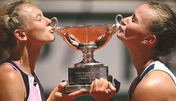 Czech Republicu2019s Barbora Krejcikova (right) and compatriot Katerina Siniakova kiss The Simonne Mathieu Cup after winning the French Open womenu2019s doubles final against Bethanie Mattek-Sands (not pictured) of the US and Polandu2019s Iga Swiatek (not pictured) in Paris, France, yesterday. (AFP)