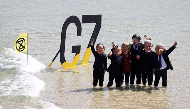 Extinction Rebellion demonstrators wearing masks depicting G7 leaders pose for a picture in St Ives Harbour, during the G7 summit, in Cornwall, Britain