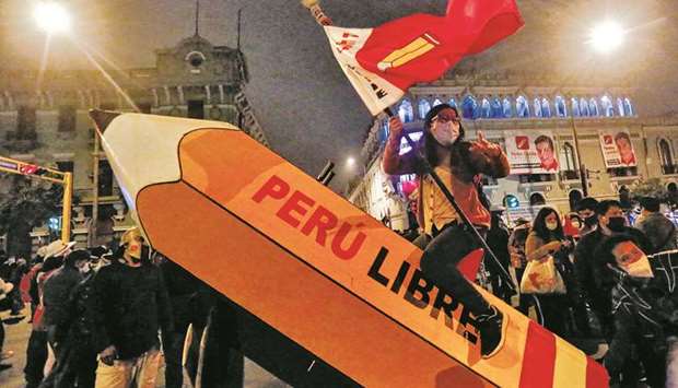 A supporter of leftist presidential candidate Pedro Castillo of Peru Libre rides a pencil, the symbol of his campaign, during a rally in downtown Lima while electoral authorities continue to review allegations of electoral fraud made by right-wing candidate Keiko Fujimori of Fuerza Popular. (AFP)