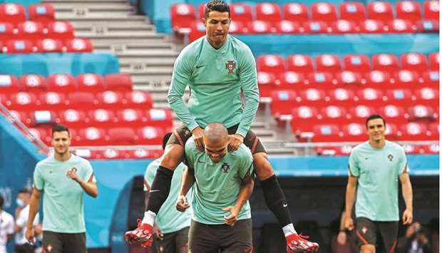 Portugalu2019s captain Cristiano Ronaldo jumps on the back of teammate Pepe during a training session in Puskas Arena in Budapest yesterday, on the eve of their UEFA Euro 2020 Group F match against Hungary. (Reuters)