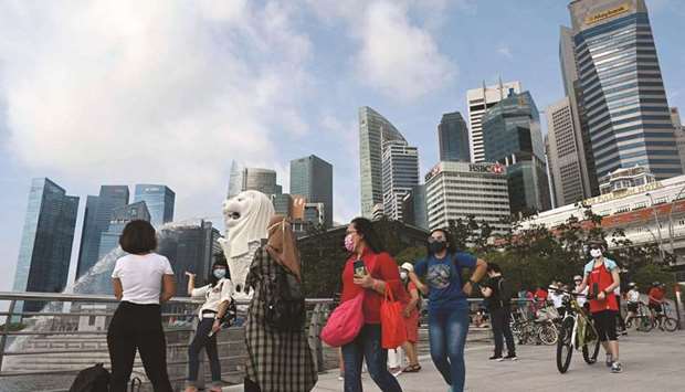 People walking past the Merlion statue in Singapore. Many officials in Singapore arenu2019t convinced Gen Z consumers are spending wisely. The Monetary Authority of Singapore has launched a media campaign warning the payment methods may lead to debt and consumer credit risk.