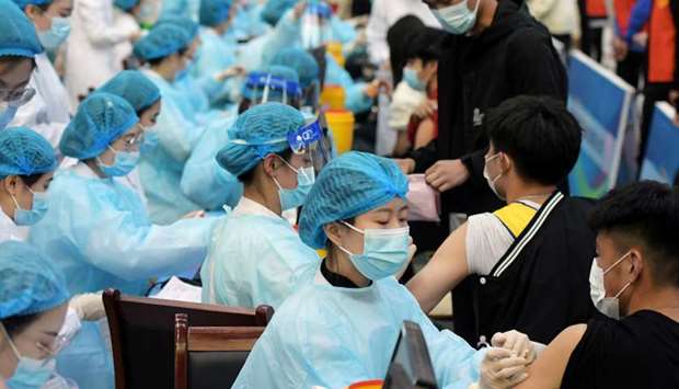 Medical workers inoculate students with the vaccine against the coronavirus disease (Covid-19) at a university in Qingdao, Shandong province, China