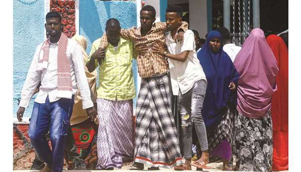 A Somali soldier, injured in a suicide bombing attack at a military base, is helped as he leaves the Madina Hospital in Mogadishu, yesterday.