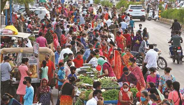 People shop at a crowded roadside vegetable market after authorities eased coronavirus restrictions, following a drop in Covid-19 cases in Ahmedabad, India, yesterday.