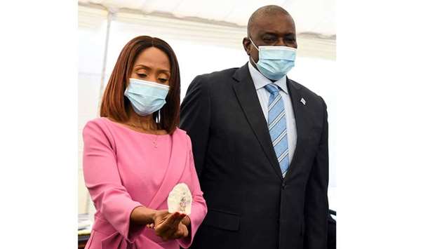 Botswana First Lady Neo Masisi holds a diamond while standing next to Botswana President Mokgweetsi Masisi in Gaborone, Botswana. Diamond firm Debswana said yesterday 2021 it had unearthed a 1,098-carat stone that it described as the third largest of its kind in the world. The stone was presented to President Mokgweetsi Masisi Wednesday by Debswana Diamond Company's acting managing director Lynette Armstrong.