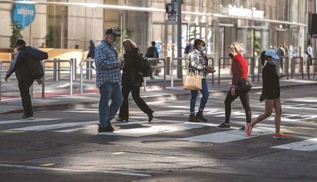People cross Mission Street in front of Salesforce Tower in San Francisco. Initial claims for state unemployment benefits rose 37,000 a seasonally adjusted 412,000 for the week ended June 12, the Labour Department said yesterday.