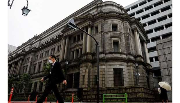 A man wearing a protective mask walks past the headquarters of the Bank of Japan in Tokyo, May 22, 2020. REUTERS