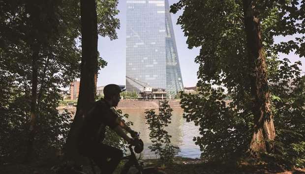 A cyclist rides past the European Central Bank (ECB) headquarters beside the River Main in Frankfurt. The ECB will allow lenders to continue to exclude deposits held at central banks when calculating their leverage ratio for nine months until the end of March next year, according to a statement from the ECB yesterday.