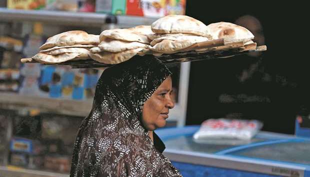 A woman carries bread as she leaves a bakery in Cairo (file). Consumer costs in urban parts of Egypt already rose at their fastest pace this year in May, growing an annual 4.8% compared with 4.1% the month before. Egypt, a major wheat importer, could feel a broader impact this summer, according to analysts.
