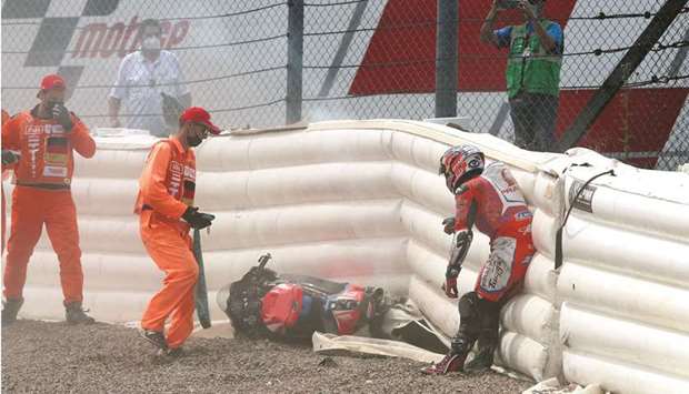 Ducati-Pramac rider Johann Zarco is assisted by track marshals after crashing during qualifying ahead of the German Grand Prix at Sachsenring circuit in Hohenstein-Ernstthal near Chemnitz, Germany, yesterday. (AFP)