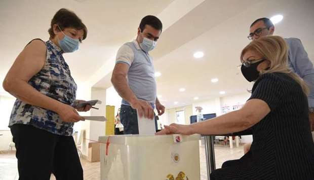 Voters cast their ballots at a polling station during early parliamentary elections in Yerevan