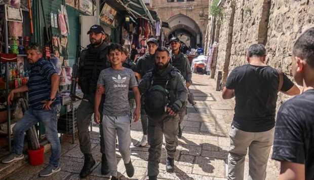 Members of the Israeli security forces detain a Palestinian youth in Jerusalem's Old City on June 18 following Friday prayers in Jerusalem's Al-Aqsa mosque complex, as Palestinians protested in response to chants by Israeli ultranationalists in the March of Flags earlier this week.