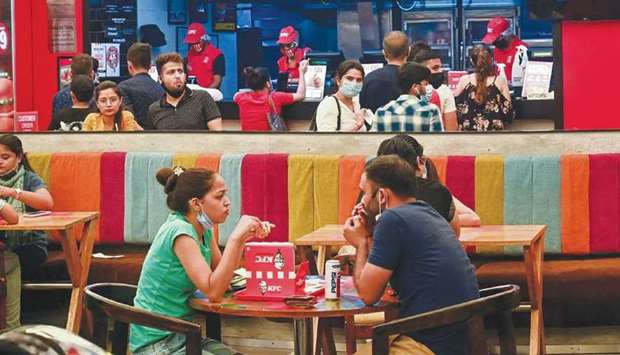 People eat a meal at a food court in Select City Mall after authorities eased a lockdown imposed as a preventive measure against the Covid-19 coronavirus, in New Delhi, yesterday.