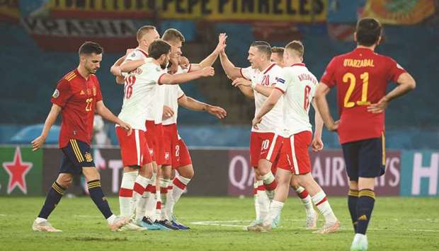 Polandu2019s players celebrate after playing out a draw in the UEFA Euro Group E match against Spain in Seville, Spain, on Saturday. (AFP)