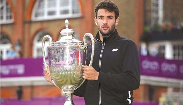 Italyu2019s Matteo Berrettini poses with the trophy after winning Queenu2019s Club tournament. (Reuters)