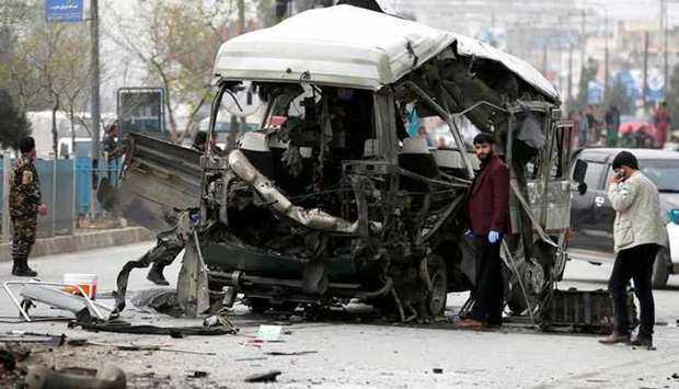 Afghan officials inspect a damaged minibus after a blast in Kabul (file photo)