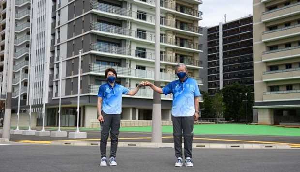 Seiko Hashimoto, president of the Tokyo Olympic Organising Committee (L) and Saburo Kawabuchi, mayor of the Olympic and Paralympic Athlete Village, pose yesterday for a photograph during a media tour at the Olympic and Paralympic Village for the Tokyo 2020 Games, constructed in the Harumi waterfront district of Tokyo